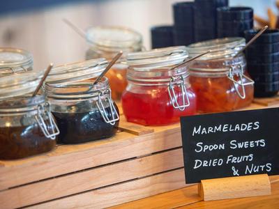 Bocaux de confitures dans une caisse en bois avec une étiquette à côté.