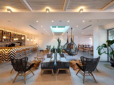 Hall d'hôtel moderne avec sièges et bar.