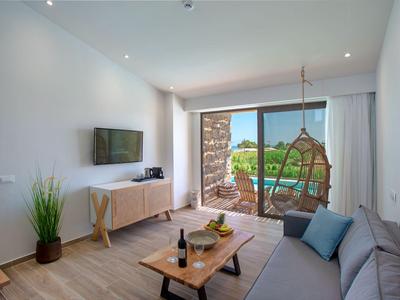 Modern living room with sofa, wooden furniture, and terrace access with a view.