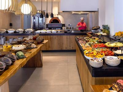 Buffet with a variety of dishes and an open kitchen in the background.
