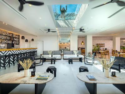 Modern bright hotel restaurant with black furniture and artwork on the walls.
