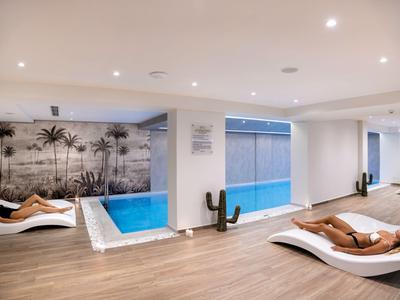 Modern wellness area with pool, sun loungers, and relaxing atmosphere.