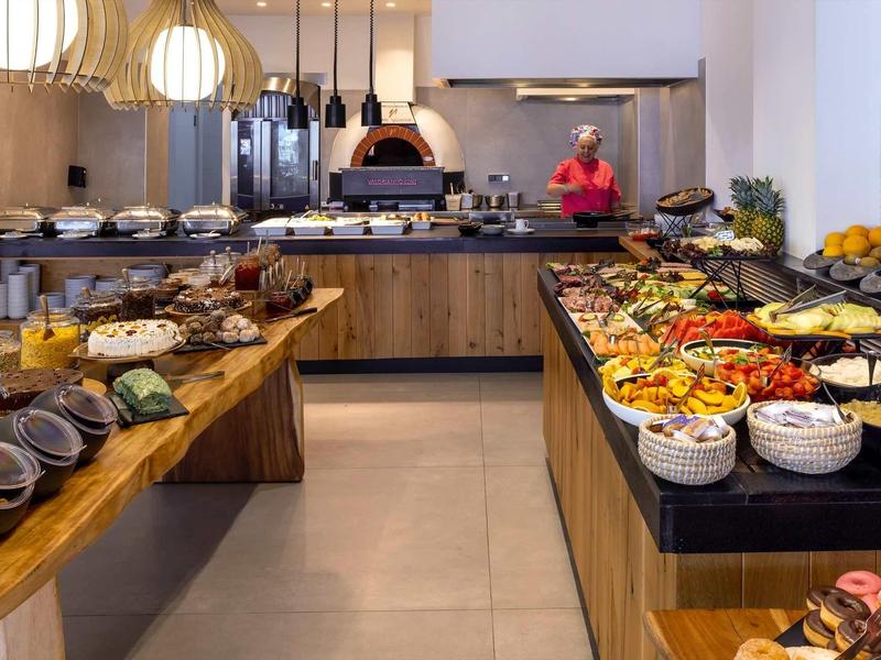 Un buffet avec une variété de plats dans un restaurant moderne avec une cuisine ouverte.