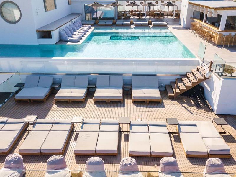 Espace piscine moderne avec transats et ambiance ensoleillée dans un hôtel.