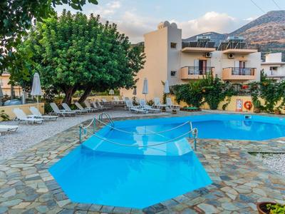 Bazén s deštníky a lehátky před hotelovou budovou v horské oblasti