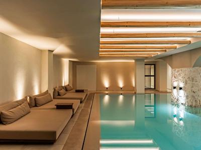 Moderní vnitřní bazén s pohodlným posezením a teplým osvětlením.