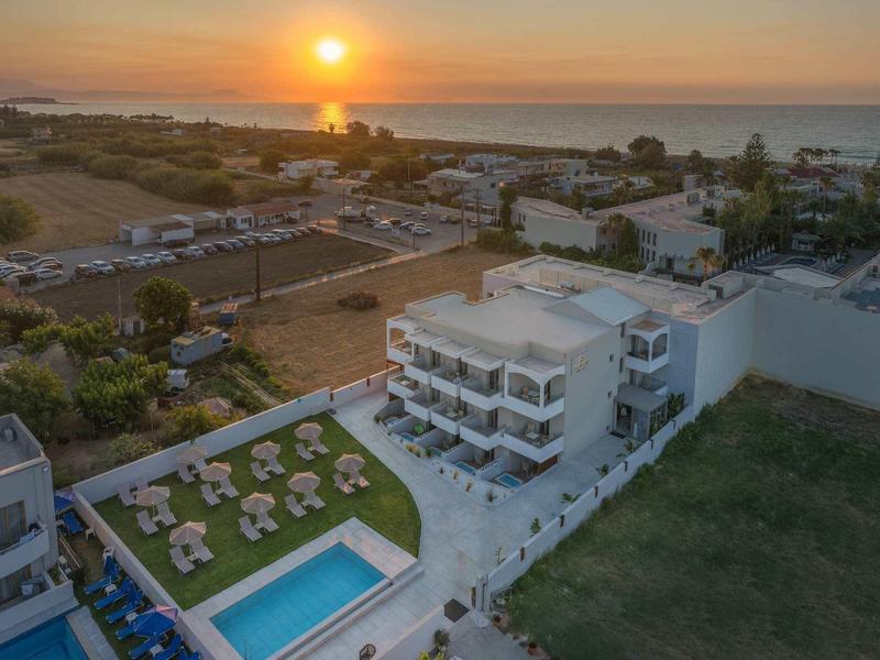 Hotel s bazénem a lehátky při západu slunce u moře.