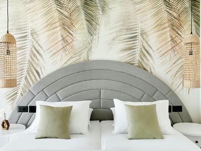 Nowoczesny pokój hotelowy z łóżkiem podwójnym, szarym zagłówkiem i tapetą z liśćmi palm