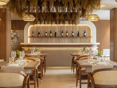 Modernes Hotelrestaurant mit elegantem Holzmobiliar und stilvoller Beleuchtung.