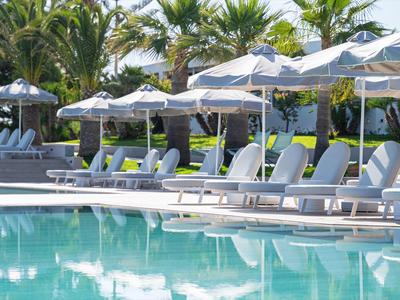 Basen z leżakami i parasolami w tropikalnym hotelu