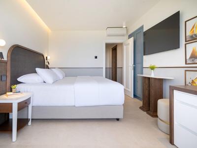 Nowocześnie urządzone pokoje hotelowe z dwoma łóżkami, szafką nocną i biurkiem.