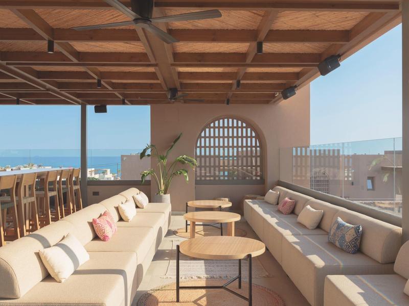 Zadaszony taras z wygodnymi sofami i widokiem na morze w hotelu.