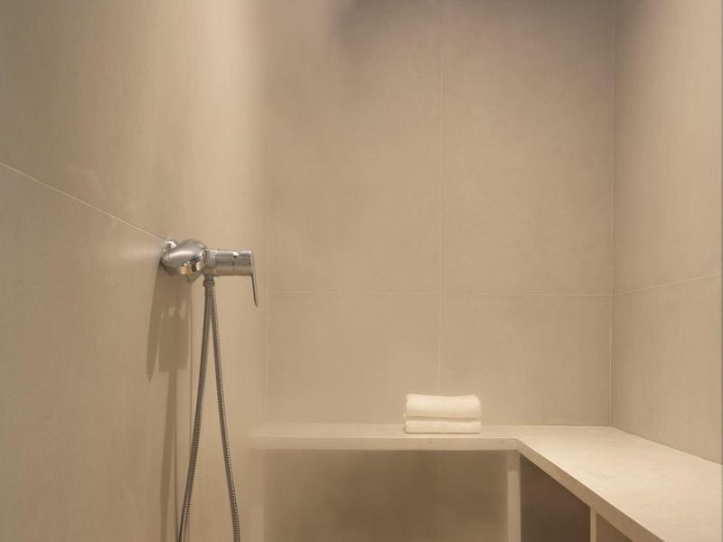 Nowoczesna kabina parowa z drewnianą podłogą i minimalistycznym designem.