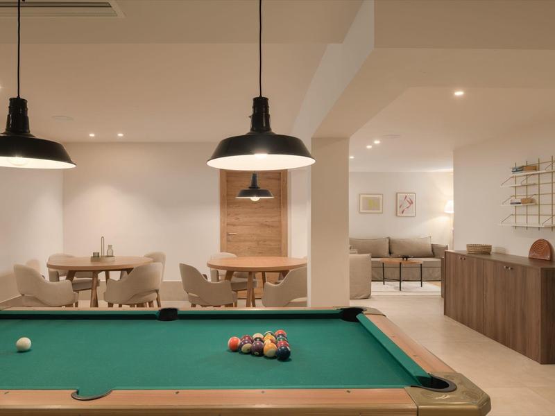 Nowoczesny pokój wypoczynkowy z stołem bilardowym i częścią wypoczynkową w hotelu.