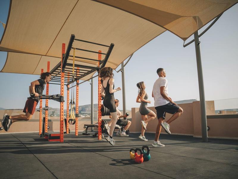 Ludzie trenują na zewnątrz pod markizami na dachu.