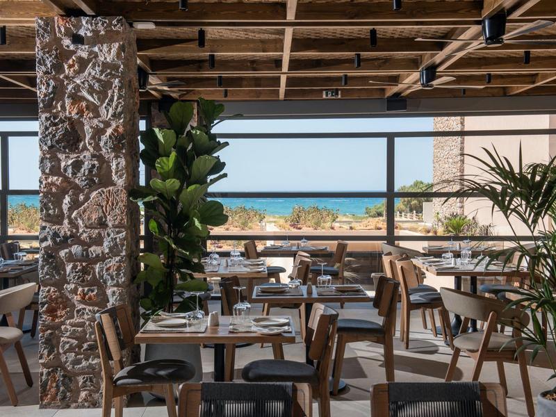 Nowoczesna restauracja z drewnianymi stołami i dużym oknem z widokiem na morze