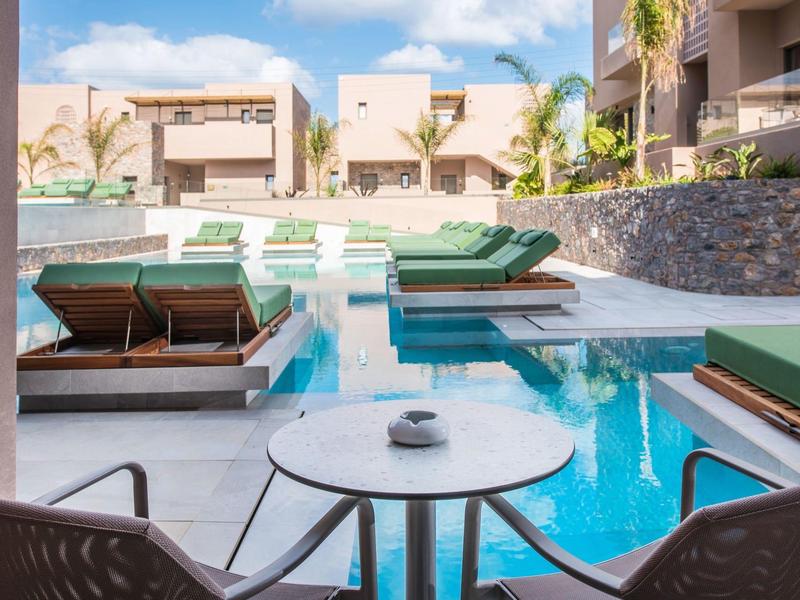 Nowoczesny basen hotelowy z leżakami i stołem z filiżankami w słonecznym otoczeniu