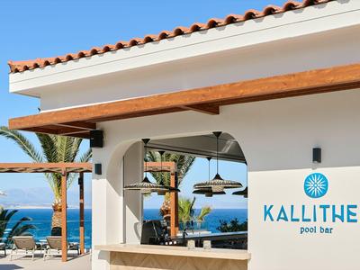 Area piscina moderna con vista sul mare, pergolato in legno e edificio bianco con logo Kallithea.