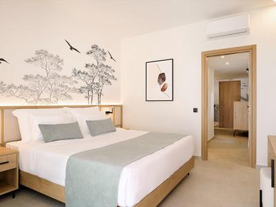 Chambre d'hôtel moderne avec grand lit, décor mural et décoration lumineuse.