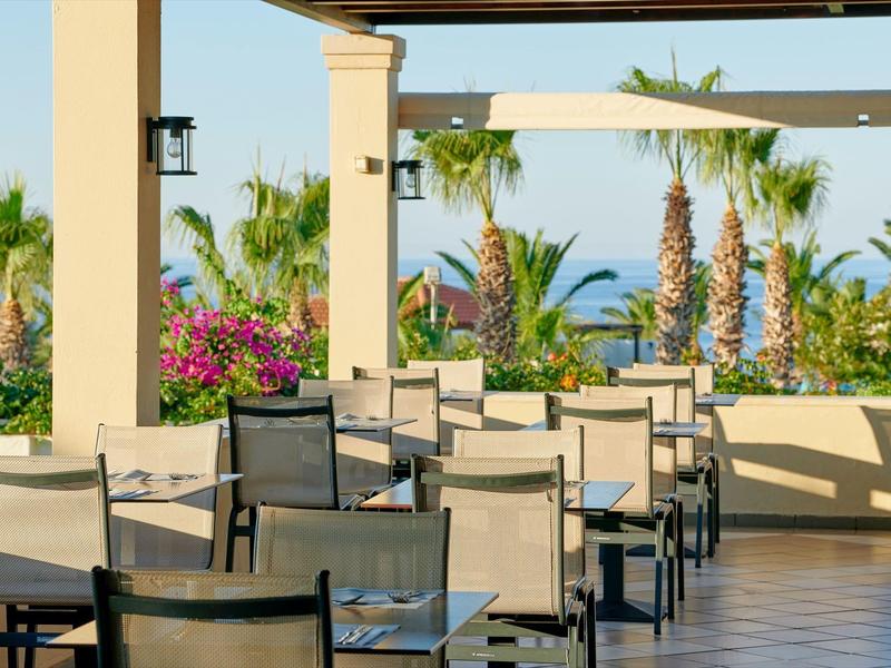 Espace extérieur vide de l'hôtel avec tables, chaises et vue sur la mer tropicale