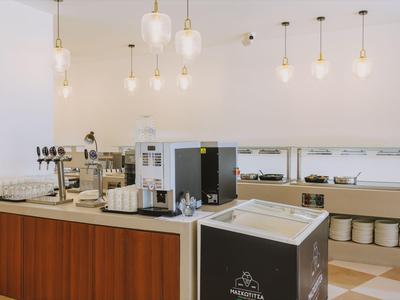 Nowoczesna stacja kawowa z ekspresem do kawy i białymi ścianami w hotelu.