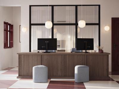 Moderne receptieruimte met houten balie, twee computers en krukken in een lichte ruimte.