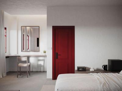 Modernes Hotelzimmer mit roter Tür, Schreibtisch, Stuhl, Bett und Minibar.