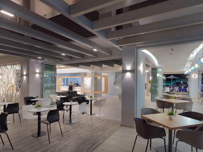 Nowoczesna przestrzeń restauracyjna hotelu z stołami, krzesłami i dekoracyjnym oświetleniem.