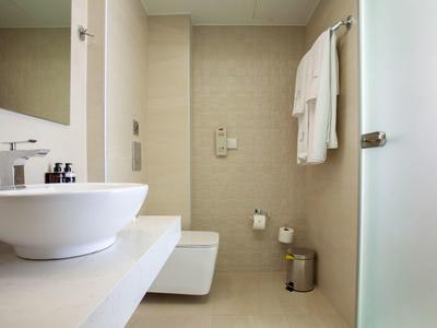 Baño moderno con lavabo, toallero e inodoro en tonos neutros.