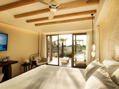 Modernes Schlafzimmer mit Holzbalken, großem Bett und Zugang zu Terrasse mit Pflanzen.