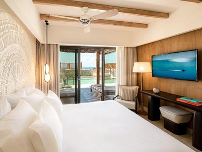 Camera d'hotel moderna con letto matrimoniale, dettagli in legno e balcone con vista sull'acqua