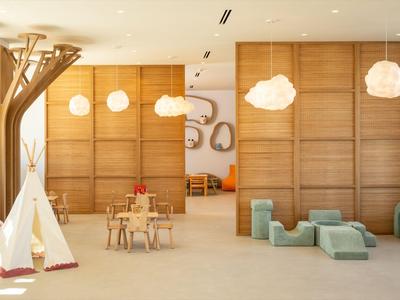 Lichte hotel lobby met houten wanden, moderne hanglampen en comfortabele loungemeubels.