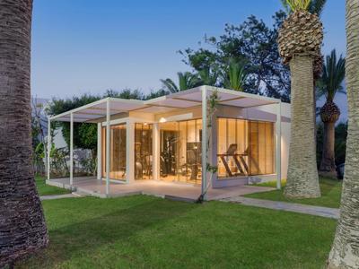 Casa vacanze moderna, ben illuminata con pareti di vetro e veranda in ambiente tropicale