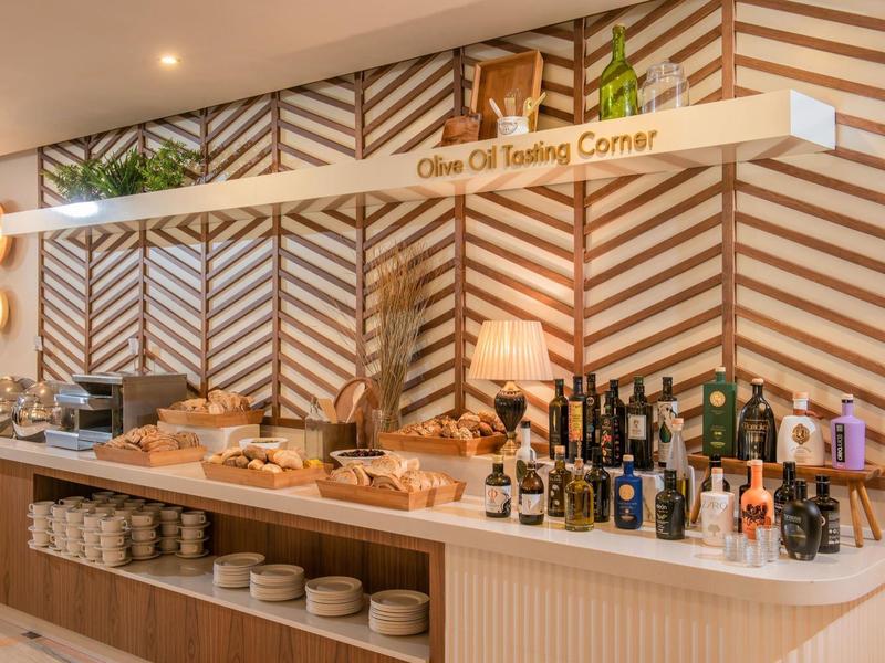 Koutek pro ochutnávku olivového oleje s lahvemi a košíky s chlebem.