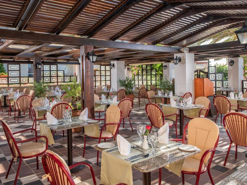 Světlá restaurace s barevnými stoly a židlemi