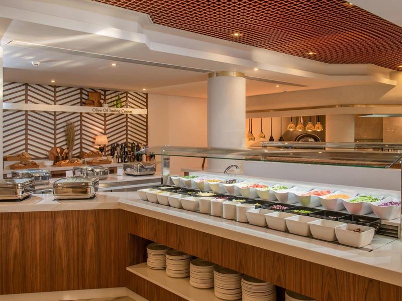 Snídaňový bufet s různými pokrmy v moderní hotelové restauraci.