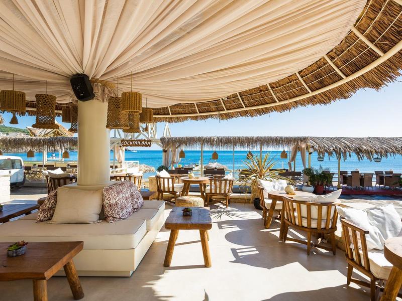 Open beach bar area with comfortable seating and a view of the sea