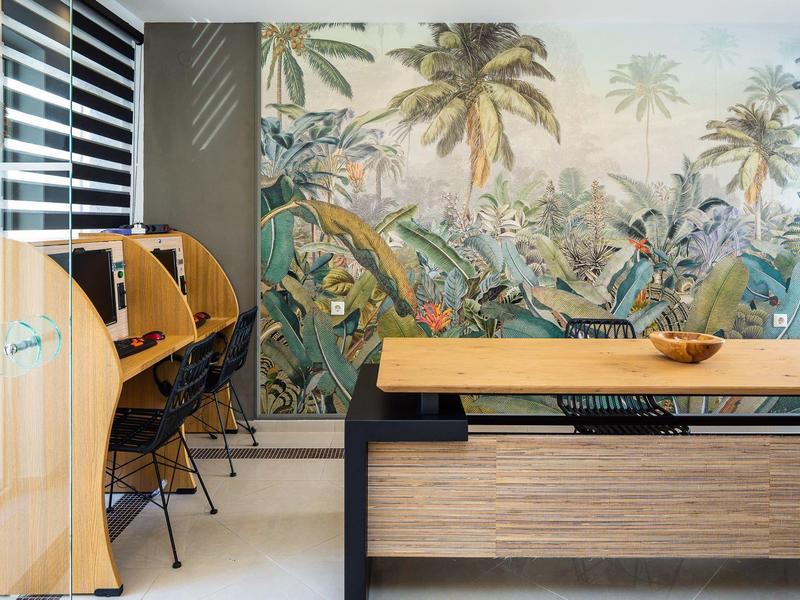 Modern room with computer desks, chairs, and tropical wall mural.