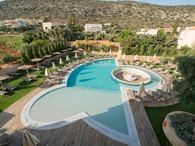Piscina dell'hotel con bacino circolare e sdraio vicino a colline e edifici