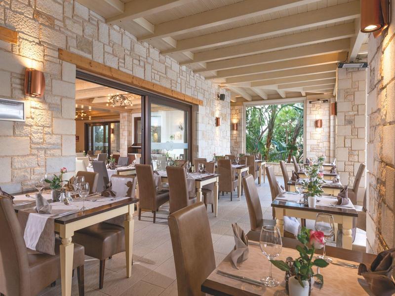 Restaurante elegante del hotel con mesas puestas y sillas cómodas en entorno natural.