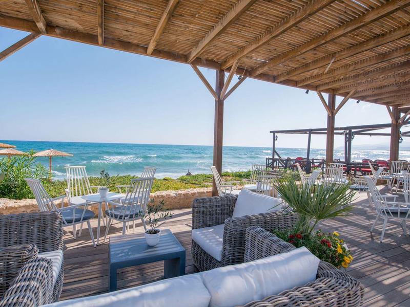 Lounge accogliente con vista sul mare sotto una copertura in legno, atmosfera rilassata.