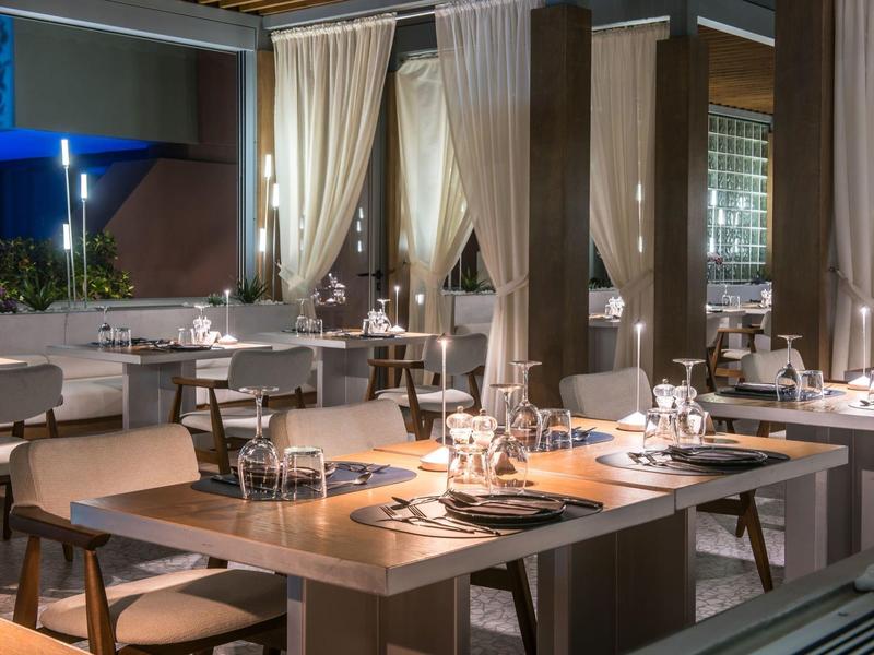 Elegant restaurant with modern decor, set tables, and soft lighting.