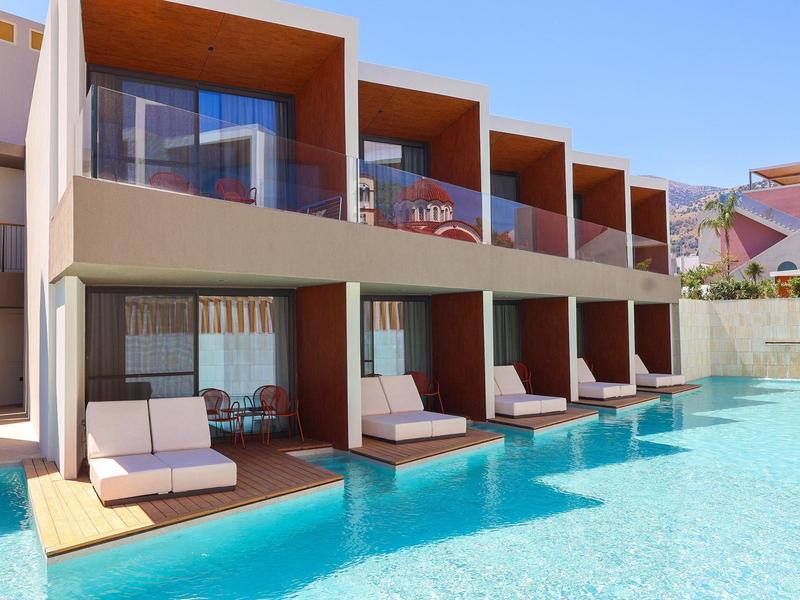Modern hotel rooms with private terraces and direct pool access on a sunny day.