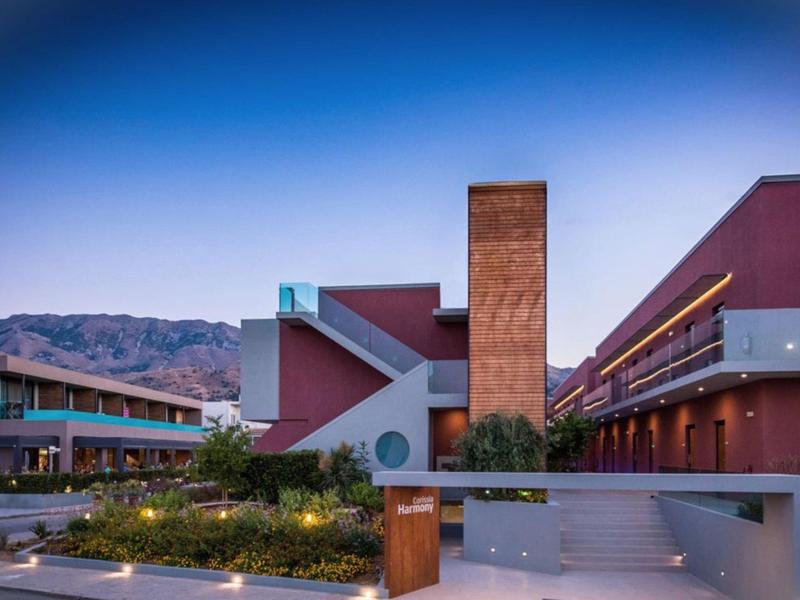 Modern hotel building with clean lines and mountain view at dusk.