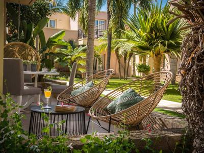 Due comode sedie e un tavolo con bevande nel giardino verde dell'hotel.