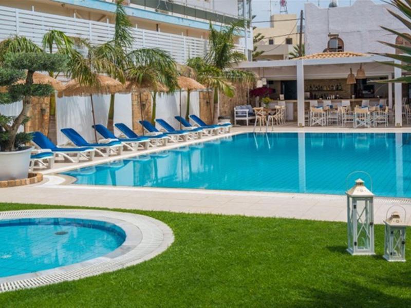 Hotelový bazén s lehátky vedle whirlpoolu a venkovního baru za slunečného počasí.