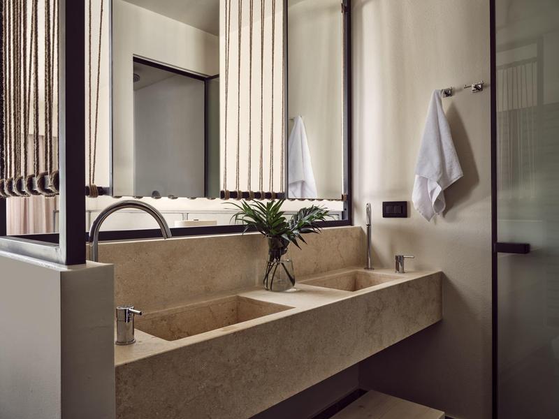 Moderner Doppelwaschtisch aus Stein mit Ablage, Spiegeln und Handtüchern im minimalistischen Bad.