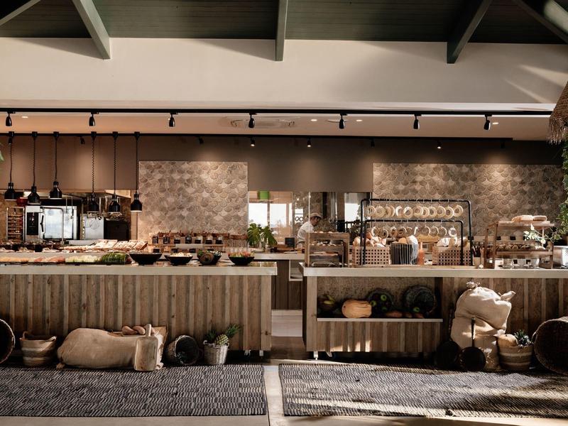 Rustikaler Marktstand mit Körben, Säcken und einer Holztheke in warmem, weichem Licht.