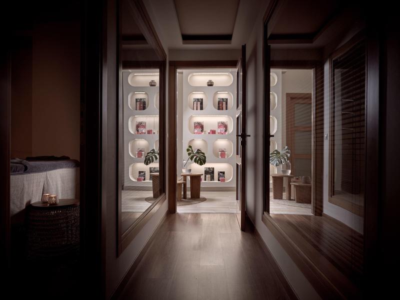 Flur mit Spiegelwänden, Sicht auf Tisch mit Blumen in einem hellen, modernen Raum.