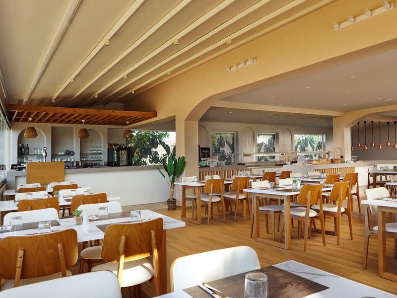 Elegant hotel restaurant with wooden floors, white tables, and wooden chairs in a bright setting.